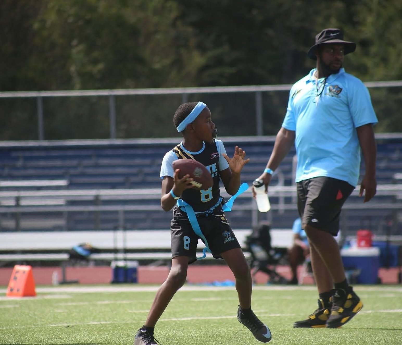 Young MCAL athlete in flag football action with coach