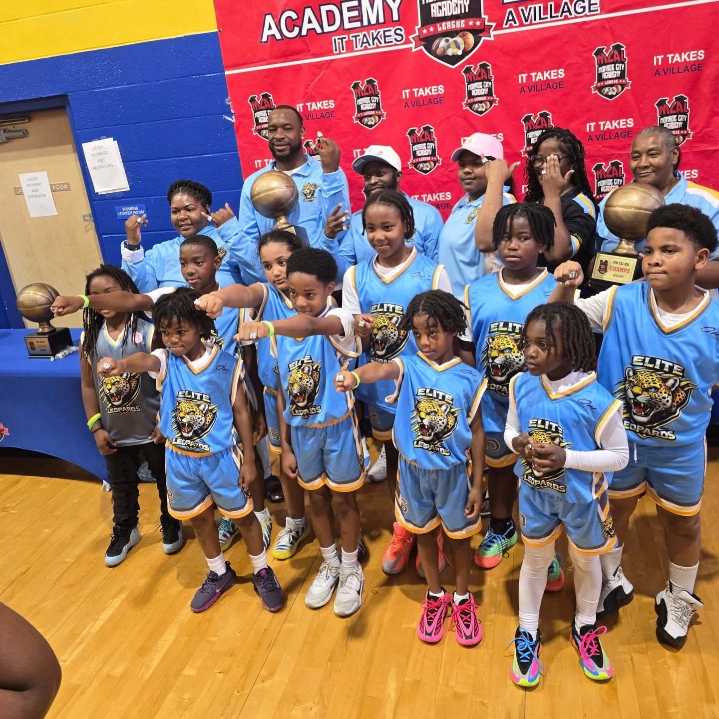 Elite Leopards co-ed basketball champions with coaches and trophies